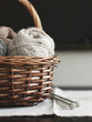 Beige wool yarn in brown wooden basket with knitting needles 