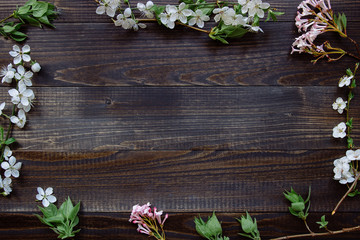 Spring background. Beautiful fresh flowers and leaves on the wooden background