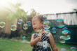 © Odua Images - little girl trying to catch soap bubbles