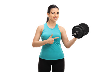 Canvas Print - Young woman lifting a dumbbell and pointing