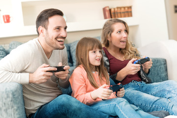 Wall Mural - Playful family playing video games at home