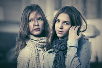 Two young fashion girls walking in a city street