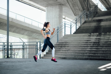 Wall Mural - Woman running in urban environment  