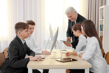 Sticker - Senior teacher and pupils working with computers in classroom