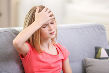 Cute girl suffering from headache at home