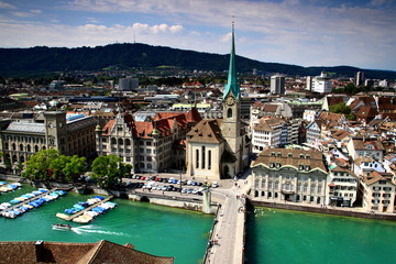 cityscape of zurich old town: the reformed fraumunster church, munsterbrucke bridge on the river lim