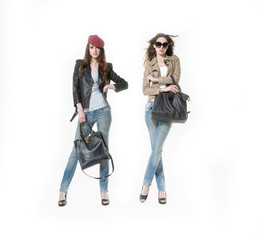 Fashion portrait of beautiful young two woman Girl in sunglasses and jeans. Girl with handbag, hat