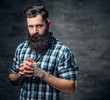 © Fxquadro - Bearded male with a tattoo on his arm dressed in a blue fleece shirt.