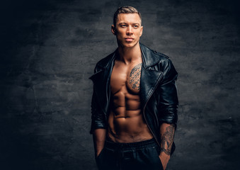 Wall Mural - A man with tattoo on a chest, dressed in a black leather jacket.