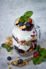 Yogurt granola jam berries dessert in mason glass jar. 