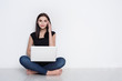 © Prostock-studio - Woman using laptop sitting on the studio floor