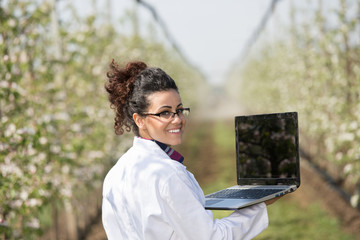 Biologist in blossoming orchard