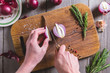 © eight8 - Chef cuts red onion on brown cutting board.