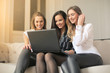 © olly - Three girl using a laptop