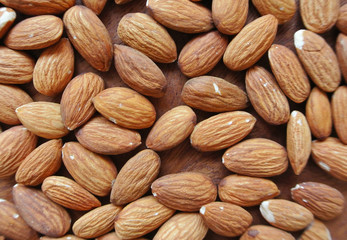 Almonds on wooden table, background.
