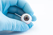 Ophthalmologist or surgeon holds in hand dressed in a blue glove eye (eyeball). Concept photo for ocular prosthesis, diagnosis and treatment of ophtalmic diseases, surgical operations on eyes