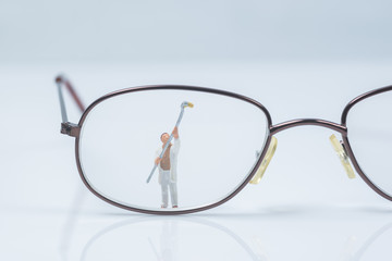 Wall Mural - miniature people worker cleaning eyes glasses