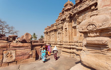 Women In Indian Sari Dresses Walking Around Architecture Landmark In Pattadakal, India. UNESCO World Heritage Site With Stone Carved Temples Of 7th And 8th-century.
