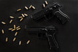 © sanmartial - handguns with ammunition on a black surface