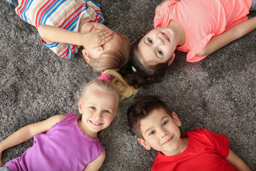 Wall Mural - Cute little children lying on carpet at home