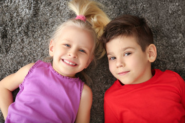 Canvas Print - Cute little children lying on carpet at home