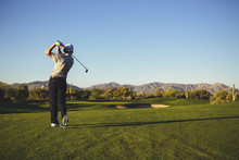 Rear View Of Man Playing Golf Against Clear Blue Sky