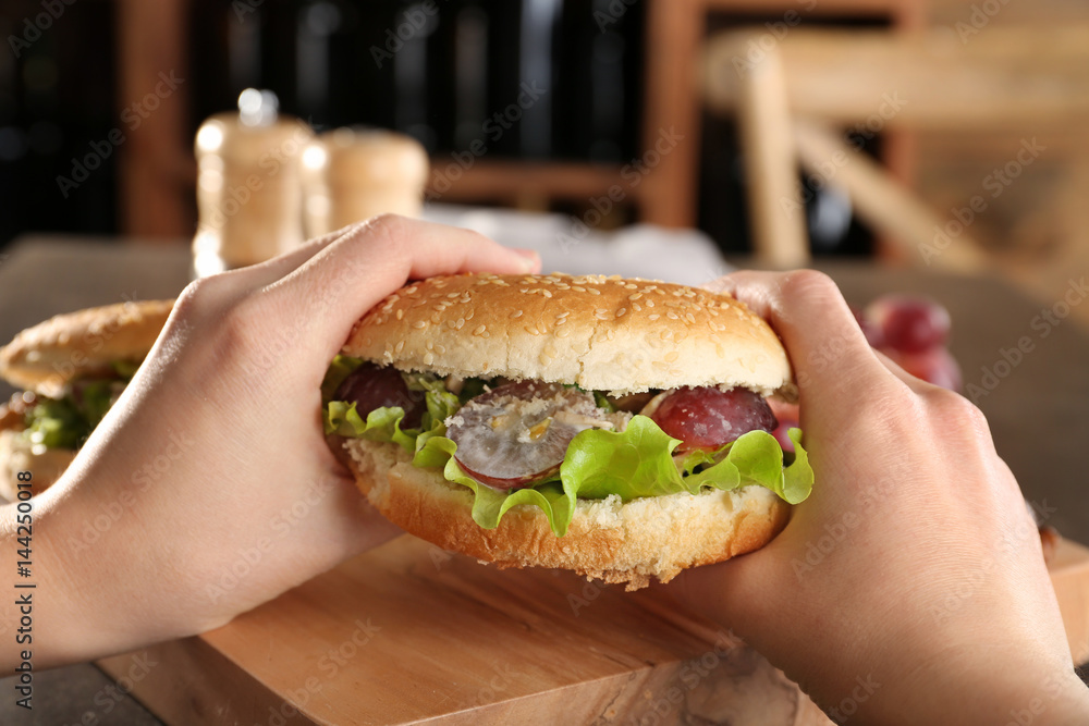 Female hands holding burger bun with chicken salad