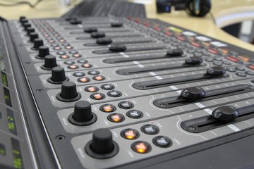 Professional audio operator working on audio mixer knobs during live TV telecast