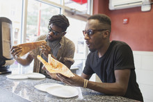 Two Young Men Eating Pizza