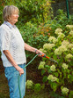 © arianarama - Gardening - senior woman is watering the flowers