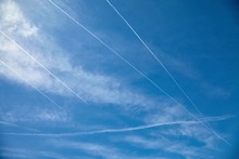 Airplanes Flying In The Blue Sky Among Clouds And Sunlight