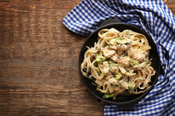 Canvas Print - Frying pan with delicious chicken Alfredo on wooden table