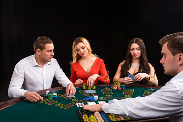 Friends enjoying a gambling night. The dealer deals the cards