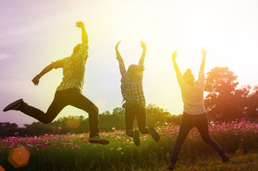 Group of friend happily jumping outdoor, sunset time