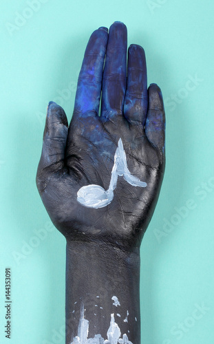 Plakat dłoń niebieskiego koloru jest narysowana nutą muzyczną