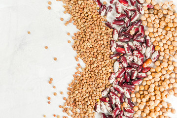 Poster - Selection of different types of beans - on a white stone concrete background: beans, chickpeas and lentils. Top view, copy space