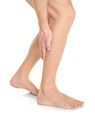 Young man suffering from pain in leg on white background