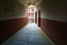 Masonry Arched Hallway Stretching Away Into The Darkness. Typical Of Forts And Prisons Of The Victorian Period