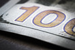 © sv_production - A fragment of a 100-dollar bill on a black table close-up.