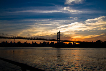 Wall Mural - Triborough bridge, fence and city with cloudy sunset sky, New York