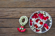 Water bowl with petal flowers and garland on old wooden table in Songkran festival