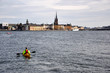 Cityscape of Stockholm with Canoe kayak flowing in the river.