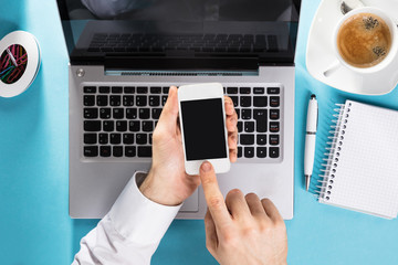 Businessman Using Mobile Phone On Laptop