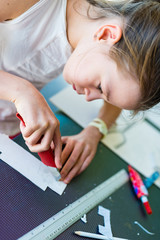 Young girl on the course of architectural design for children - preparing architectural model
