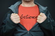 a man with the word believer on his red t-shirt 