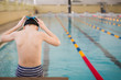 © goodmoments - Cute little boy ready to dive in the sport swimming pool. Indoors. Sport activities for children. Training for competition.