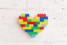 Top  View  On Bright Heart Made Of  Colorful Plastic Bricks On Old Wooden Background Or Table. Creative Building Out Of Bright Constructor Bricks. Early Learning. Developing Toys