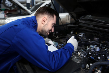 Wall Mural - Mechanic repairing car with open hood