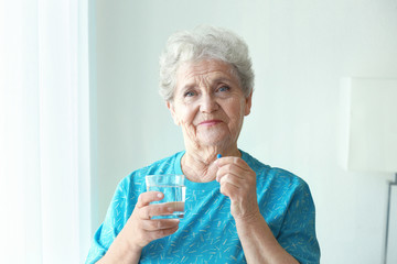 Poster - Elderly woman taking pill at home