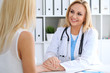 © rogerphoto - Doctor reassuring her female patient. Medicine, help and health care concept.